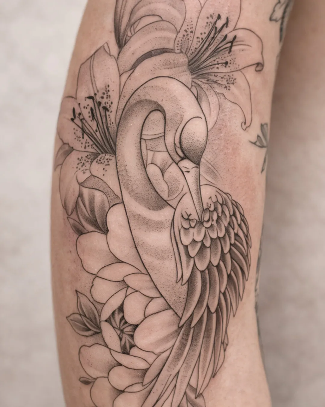 Oiseau parmi des lys et des pivoines, trait fin et ombré léger, sur le bras
